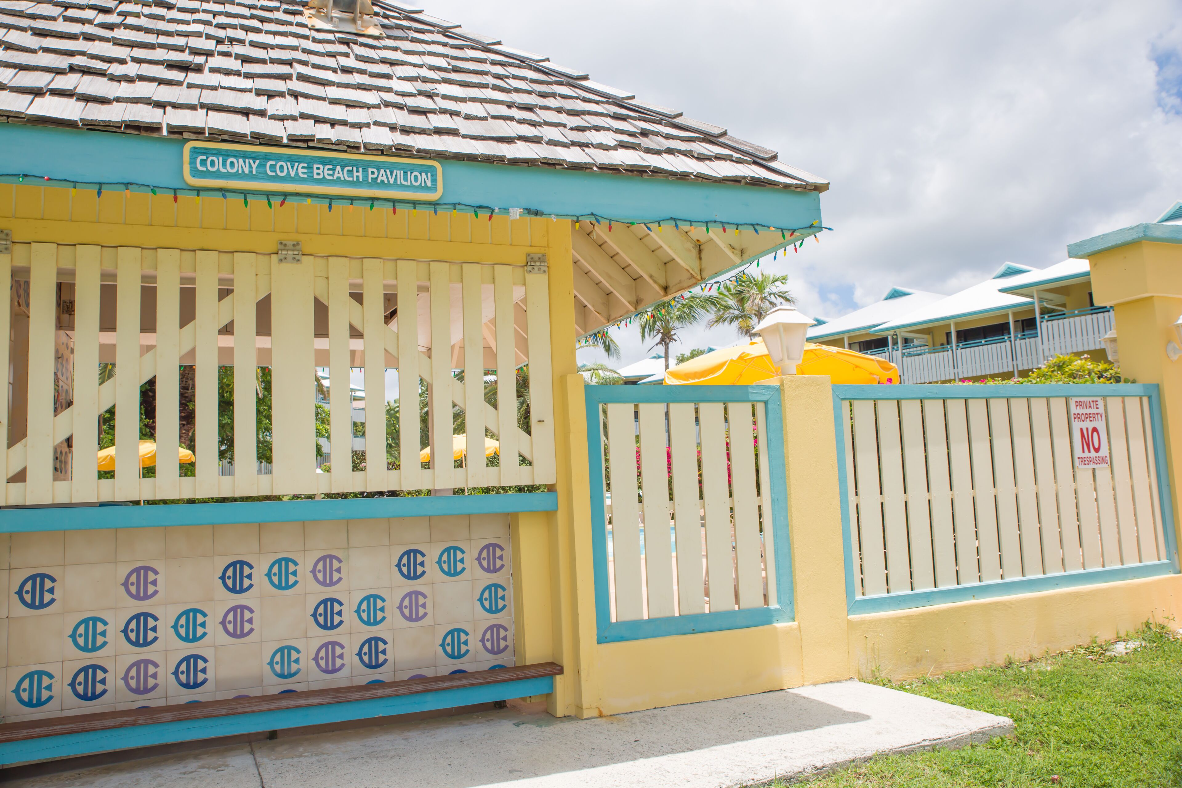 Un bâtiment sur lequel on peut lire l’inscription « Colony Cove Beach Pavilion », avec une entrée fermée par un portail.