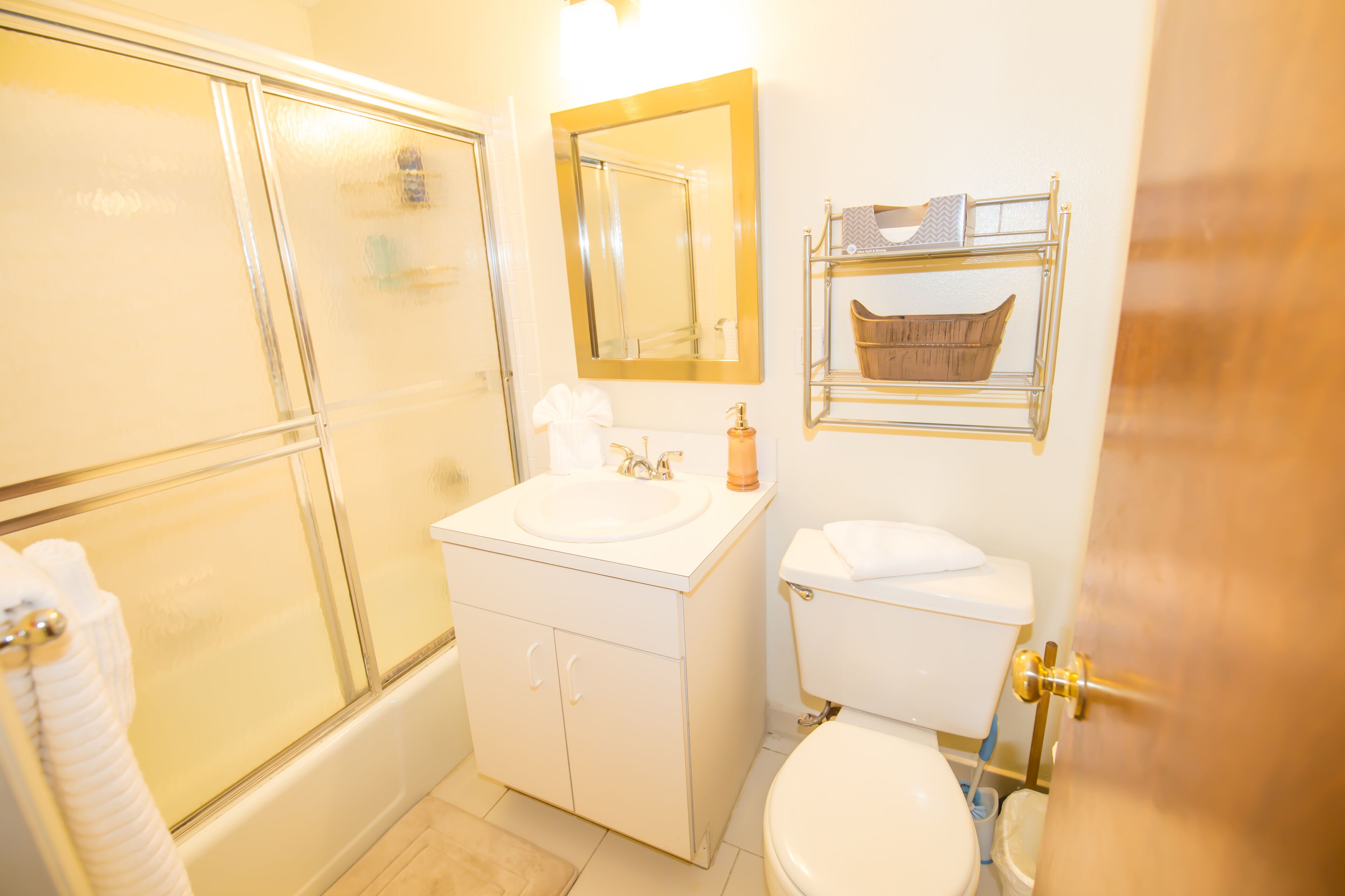 A bathroom with a bathtub, a sink, a toilet, and a mirror.