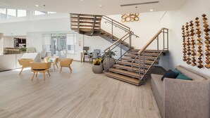 A spacious lobby with a modern staircase, a seating area with chairs, and a reception desk. - Element by Marriott Denver International Airport (Denver)
