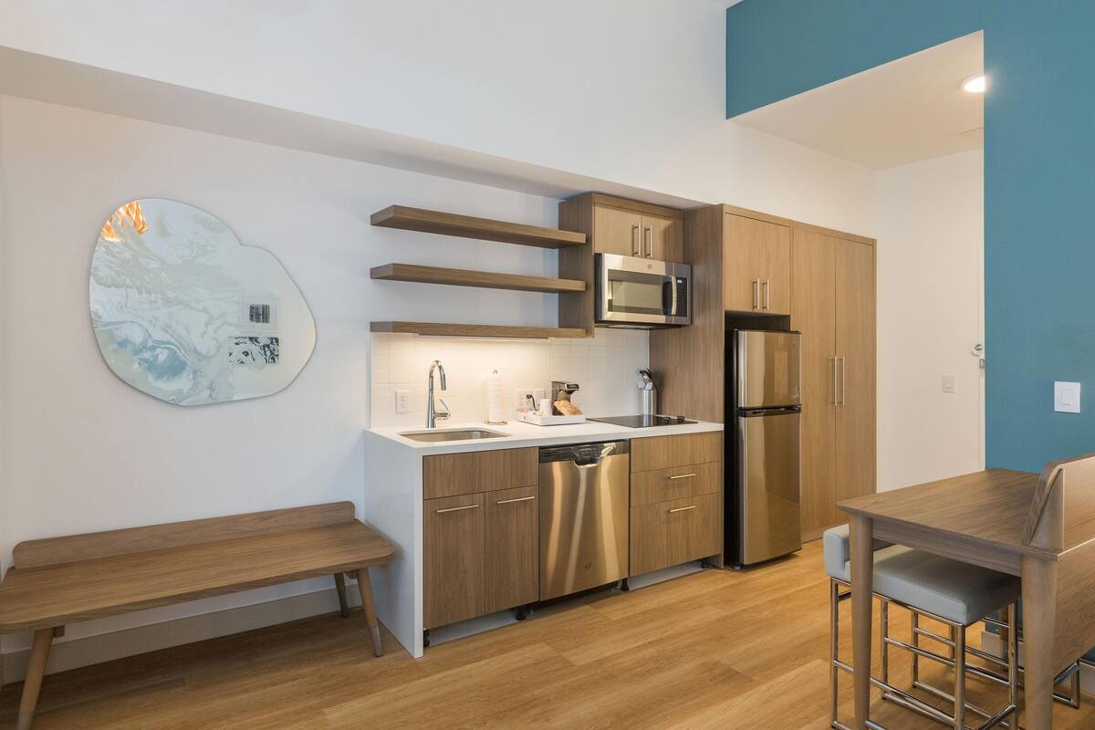 Eine moderne Küche mit Holzschränken, Edelstahlgeräten und einer Marmor-Spritzschutzwand.