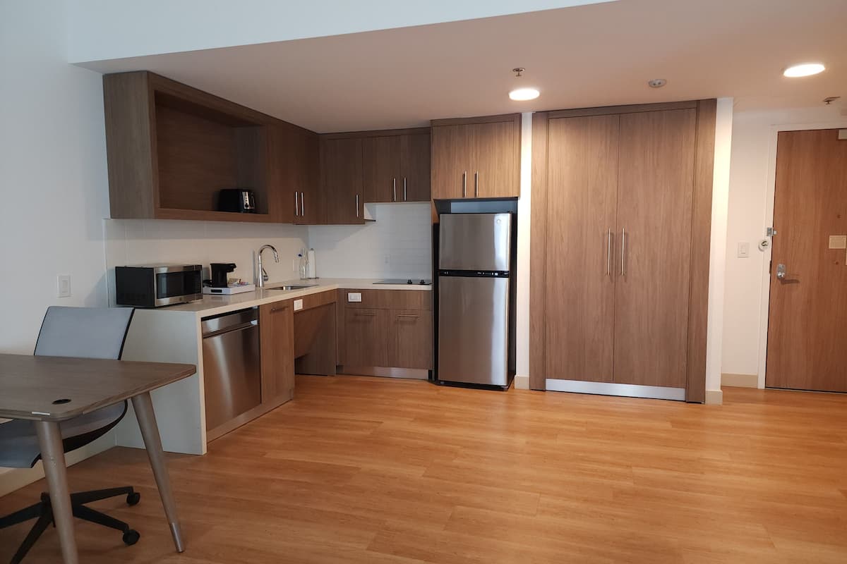 Eine moderne Küche mit Holzausstattung, Edelstahlgeräten und einem Essbereich mit Tisch und Stühlen.
