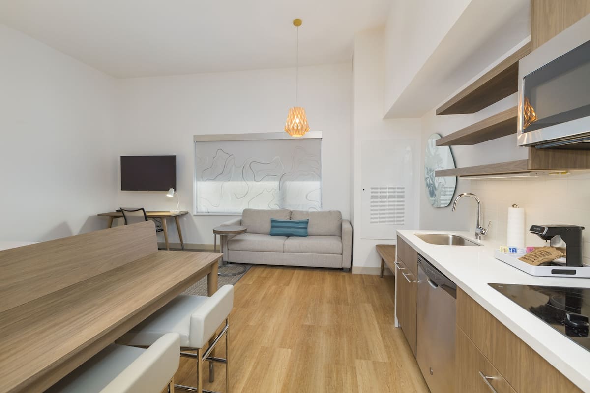 desk, laptop workspace, iron/ironing board, bed sheets