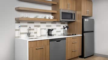 Una cocina moderna con armarios de madera, un refrigerador de acero inoxidable, un microondas y un lavavajillas.