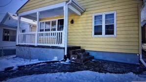 A single-story house with a porch, a small front yard, and a snow-covered ground. - 15 mins walk to The old market area,  Its called Easy peasy (Omaha)