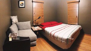 A compact bedroom with a single bed, a sofa, a bedside table, and a lamp. - 15 mins walk to The old market area,  Its called Easy peasy (Omaha)