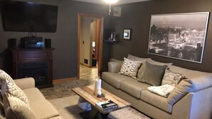 A living room with a sofa, coffee table, and a flat-screen TV. - 15 mins walk to The old market area,  Its called Easy peasy (Omaha)