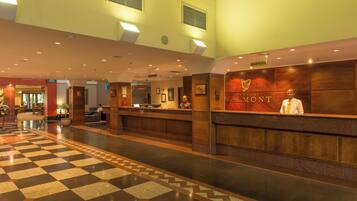 A hotel reception area with a check-in counter, a reception desk, and a check-in counter.
