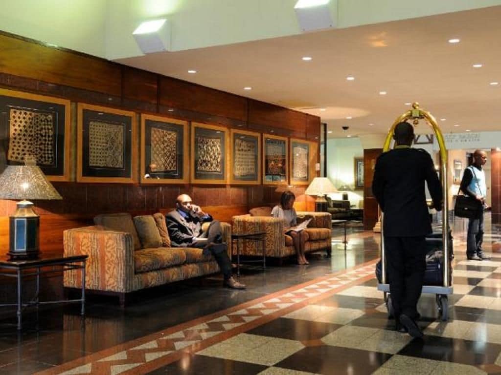 A lobby with seating areas, a reception desk, and a check-in counter.