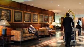 A lobby with seating areas, a reception desk, and a check-in counter.