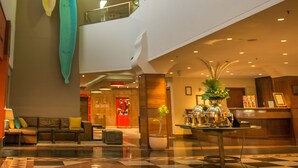 A multi-level hotel lobby with a checkered floor, a reception desk, and a seating area. - Peermont Walmont Ambassador at the Grand Palm (Gaborone)