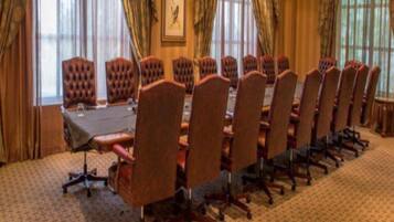 A conference room with a long table and multiple chairs.
