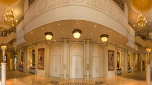 A grand lobby with a curved ceiling, multiple doors, and chandeliers. - Peermont Walmont Ambassador at the Grand Palm (Gaborone)