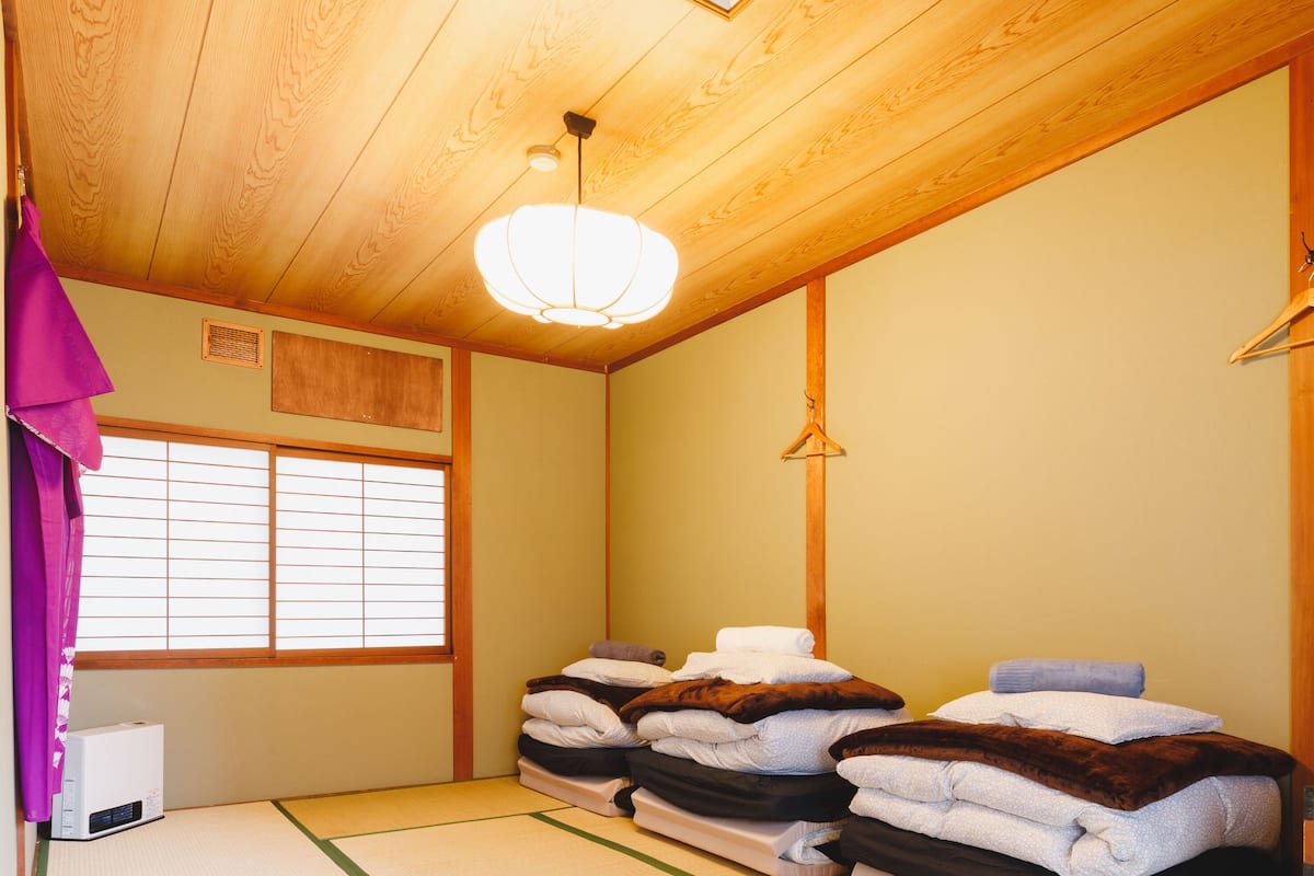 Ein traditioneller japanischer Raum mit Tatami-Böden, Shoji-Schirmen und einer Holzzielung.