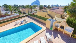 A swimming pool with lounge chairs, a view of a mountain, and a cityscape in the background. - Vacation home Gao by Interhome (Calpe/Calp)