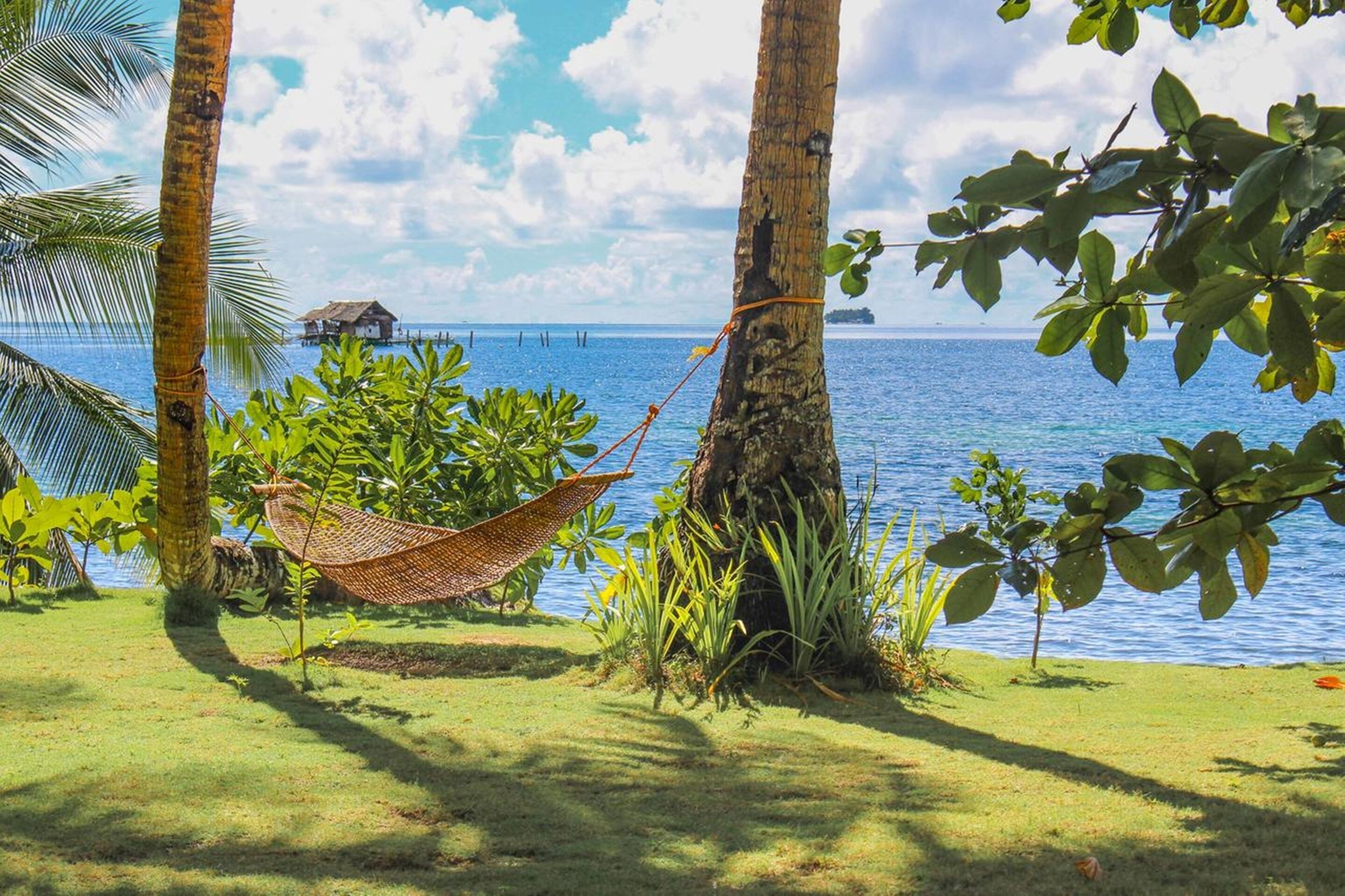 Di pantai, pasir putih, kursi berjemur, dan handuk pantai