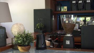 A kitchen counter with a coffee maker, a potted plant, and a decorative vase.