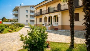 A building with a courtyard, a staircase, and a palm tree.