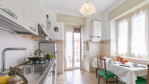 Una cocina moderna con estufa, lavamanos y comedor con mesa y sillas.