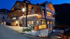 Un hôtel moderne à la façade en pierre, doté de nombreux balcons et d’une enseigne indiquant le nom « Somleiten ».