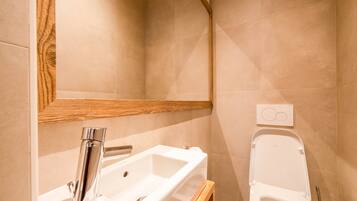 Un bagno con lavandino, specchio e water.