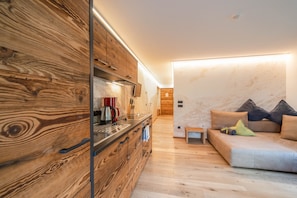 A modern kitchen with wooden cabinetry, a built-in stove, and a countertop with a coffee maker.