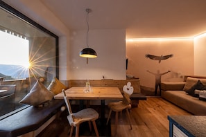 Un interior moderno con una mesa de comedor de madera, sillas, un sofá y un mural en la pared.