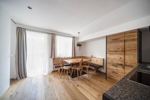 Uma cozinha moderna com armários de madeira, uma mesa de jantar com cadeiras e um banco.