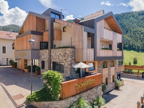 A modern building with a stone facade, wooden accents, and a sign reading 'Somleiten.'