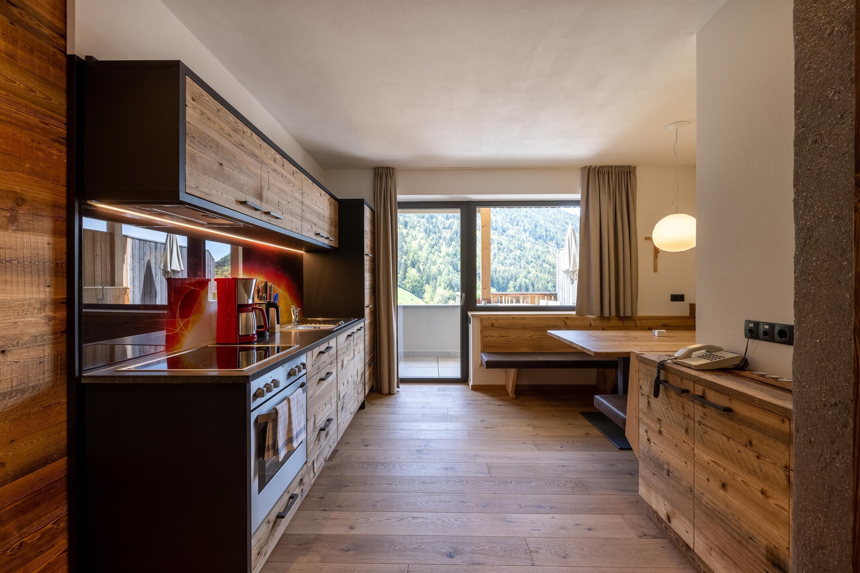Une cuisine moderne avec des meubles en bois, un îlot central et une vue sur l’extérieur.