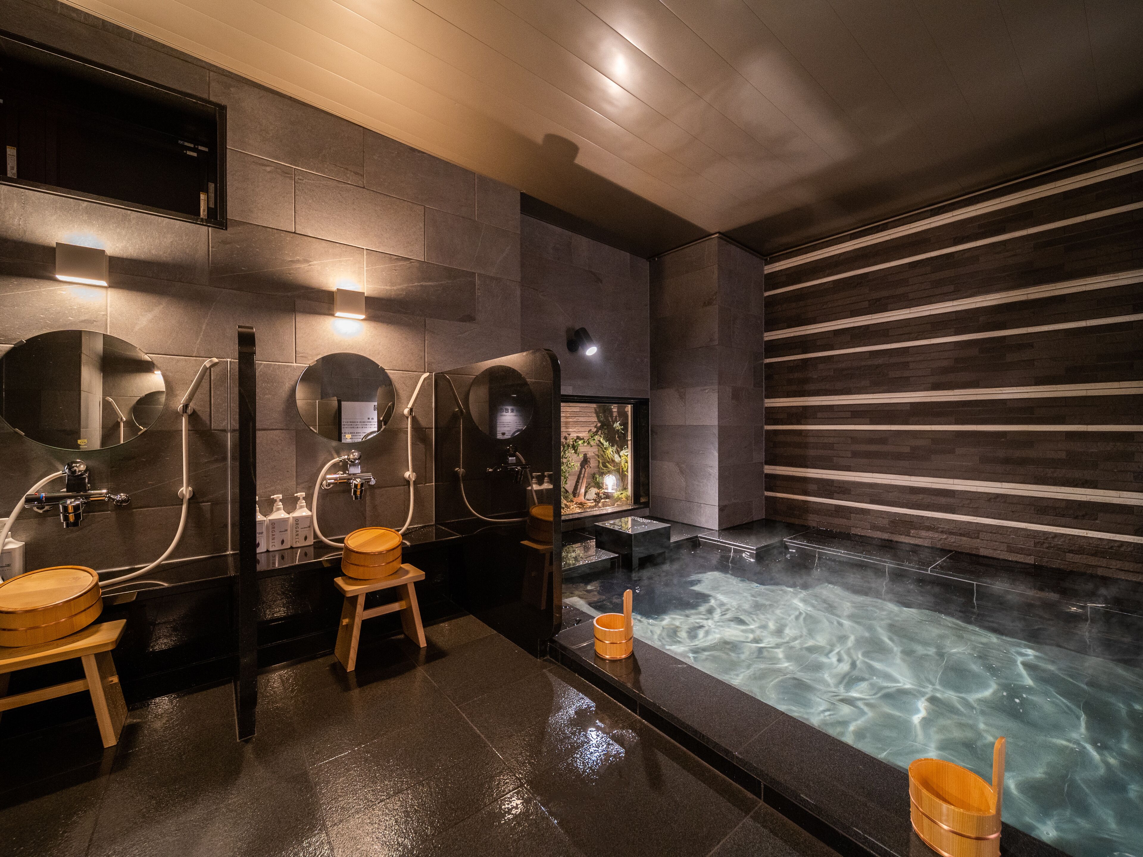 Une salle de bain moderne dotée d’une douche à vapeur, de plusieurs miroirs et d’une grande baignoire.