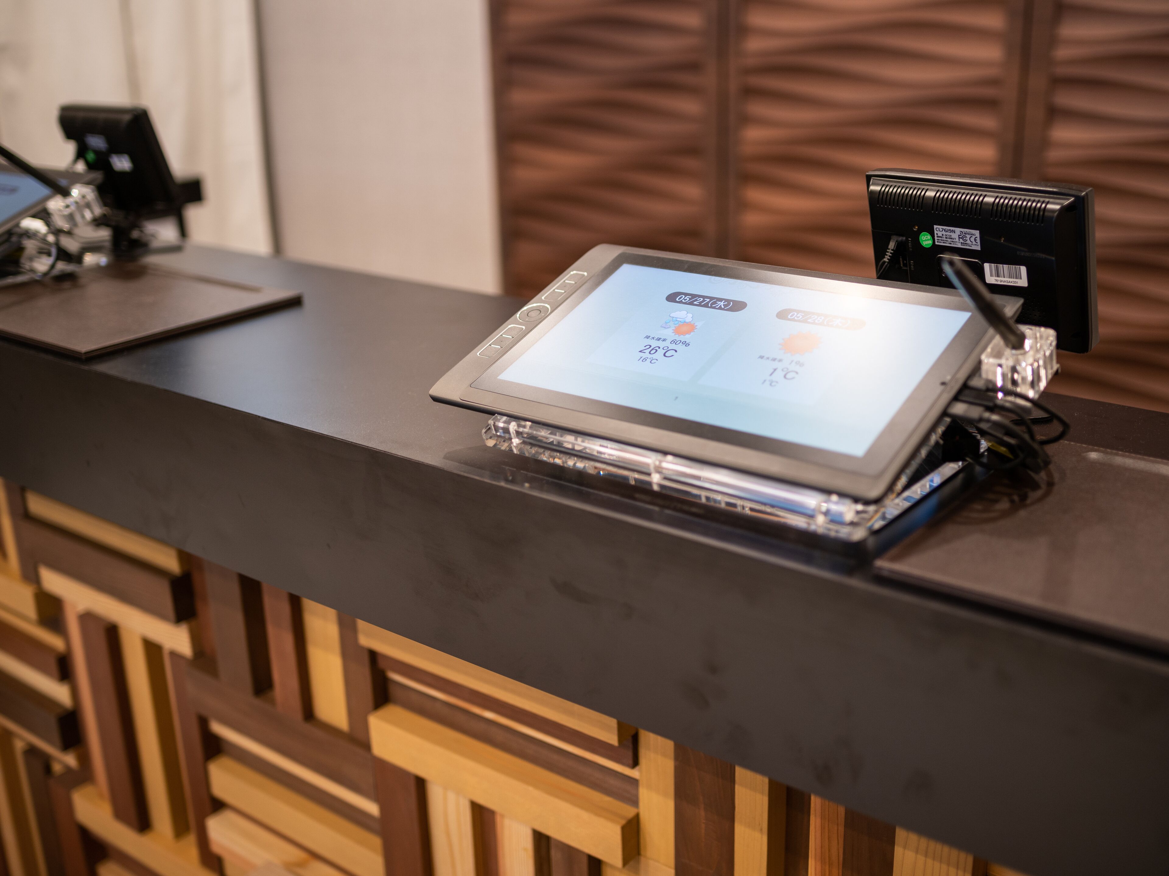 A reception desk with a digital display showing the time and temperature.