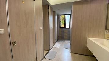 Un baño moderno con un lavamanos grande, un espejo y una zona de ducha.