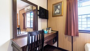 A room with a wooden desk, a chair, a television mounted on the wall, a framed picture, and a window with curtains. - Sipadan Inn 1 (Semporna)