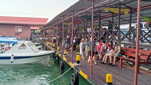 A docked boat with people sitting on a covered walkway. - Sipadan Inn 2 (Semporna)