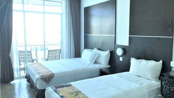 Habitación de hotel con dos camas, un ventanal grande con cortinas, un balcón con sillas y un diseño moderno.