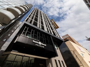 Un edificio de hotel moderno con un llamativo letrero que dice 'Smile Hotel Premium'.