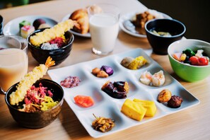 Una variedad de platillos y bebidas sobre una mesa, incluyendo un vaso de leche, un tazón de nueces mixtas y varias fuentes pequeñas de comida.