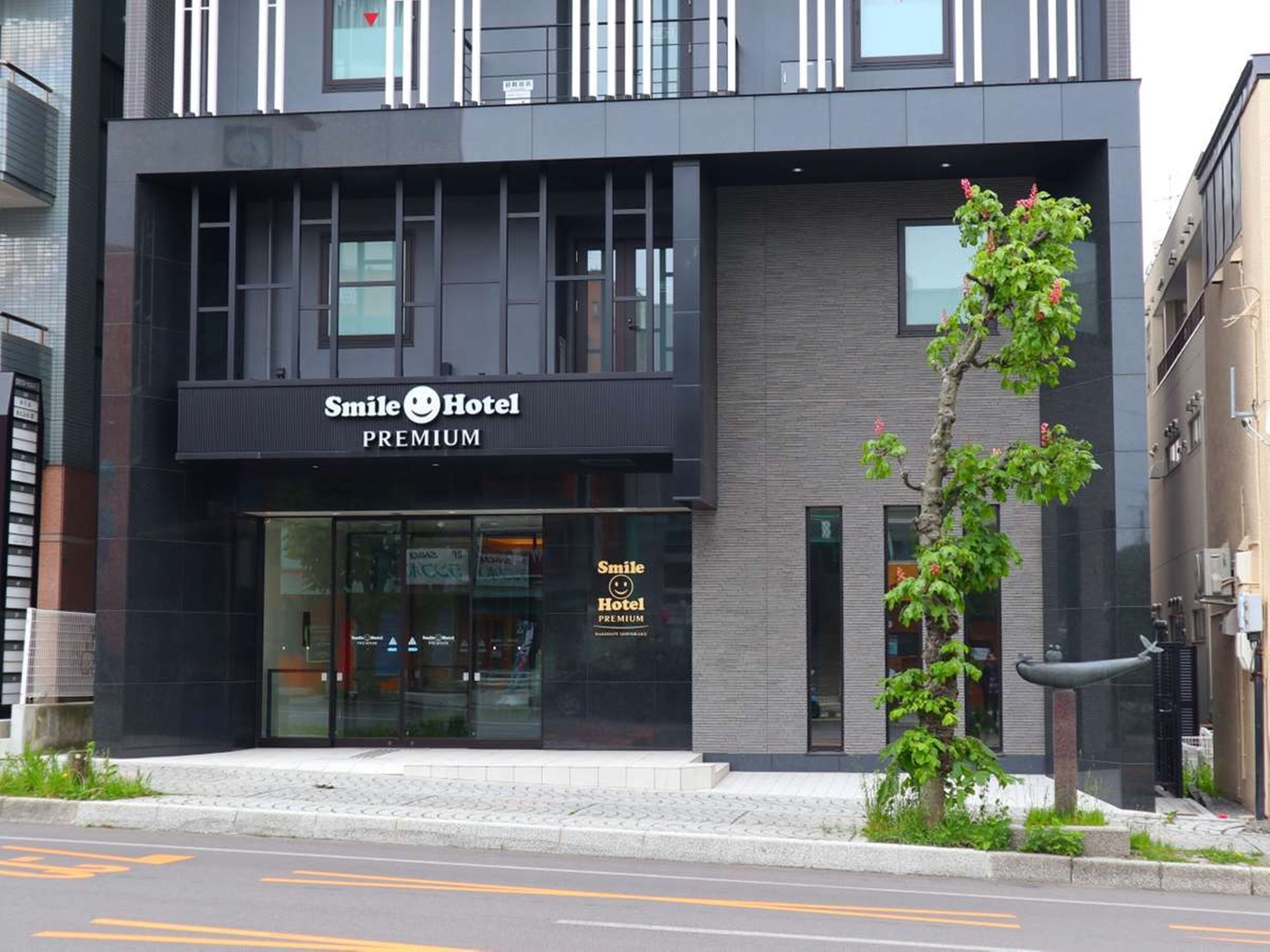 A modern hotel building with a sign reading "Smile Hotel Premium."