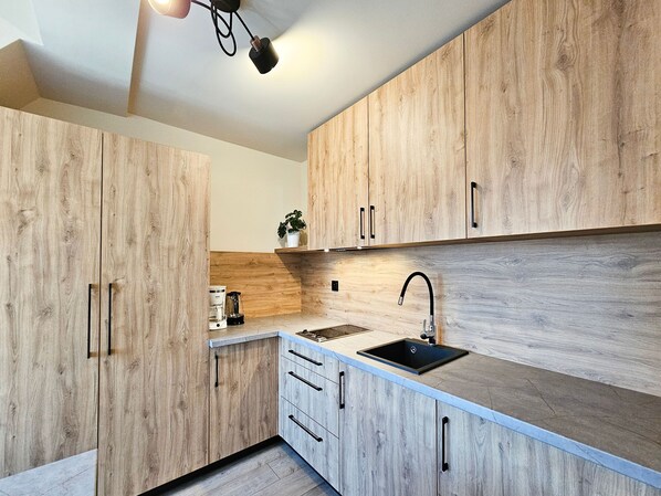 Une cuisine moderne avec des meubles en bois, un évier et un plan de travail.