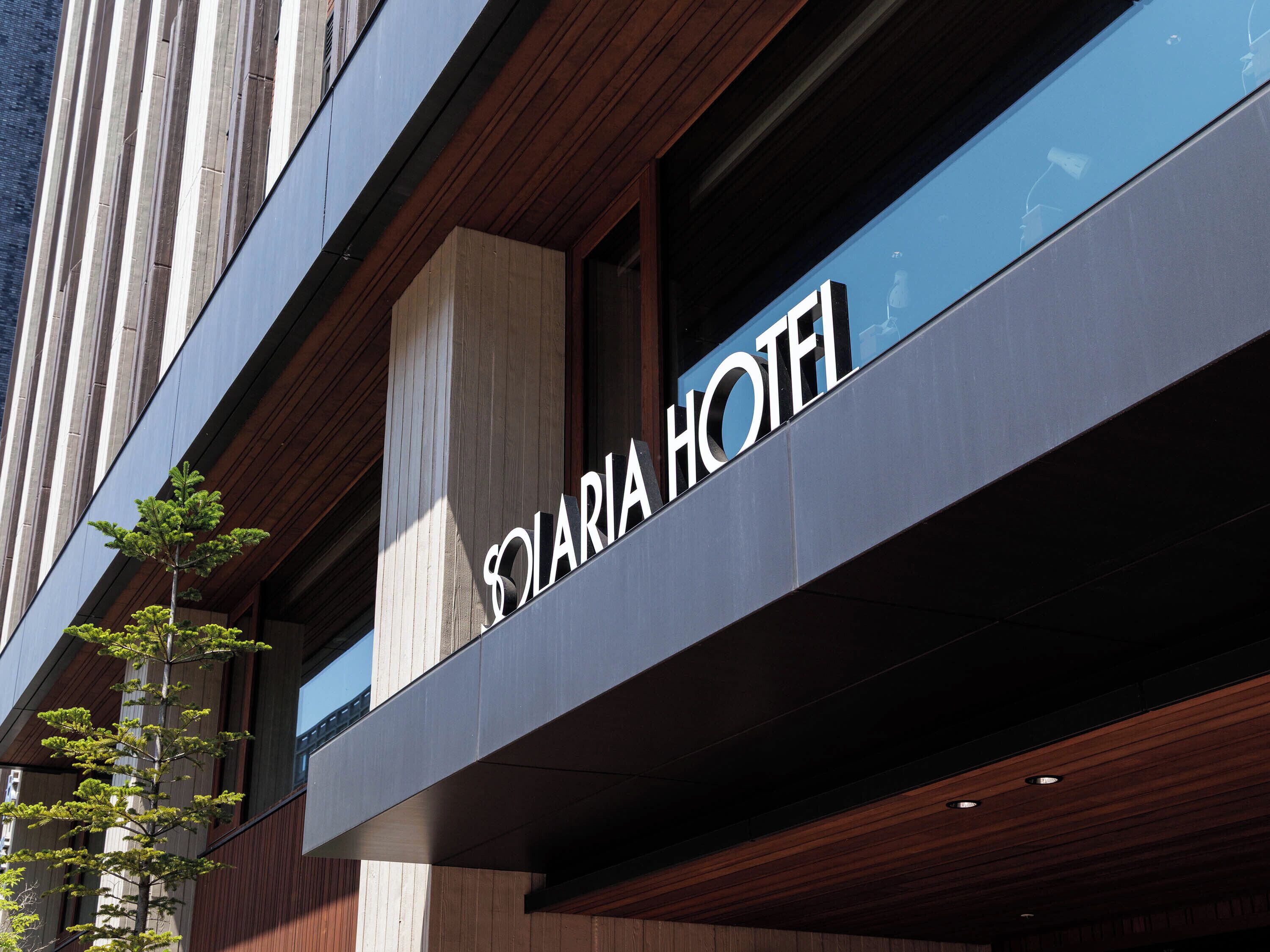 A hotel sign with the name "SOLARIA HOTEL" on a modern building facade.