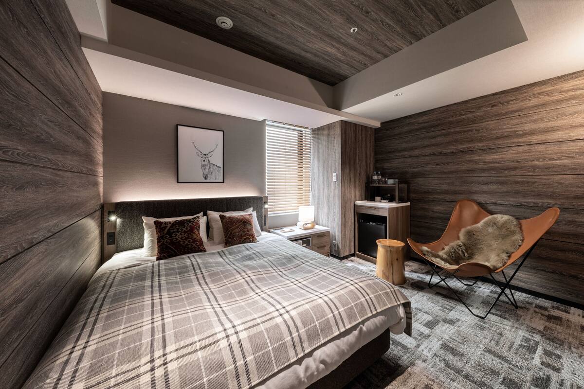 A modern bedroom with a large bed, a chair, and a desk.