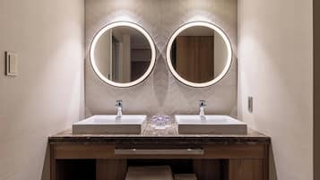 A modern bathroom with two sinks, a double mirror, and a wooden vanity.
