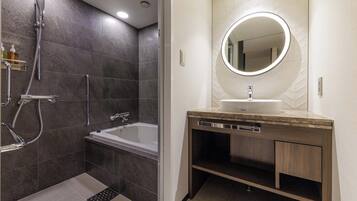 A modern bathroom with a bathtub, a shower, and a vanity with a mirror.