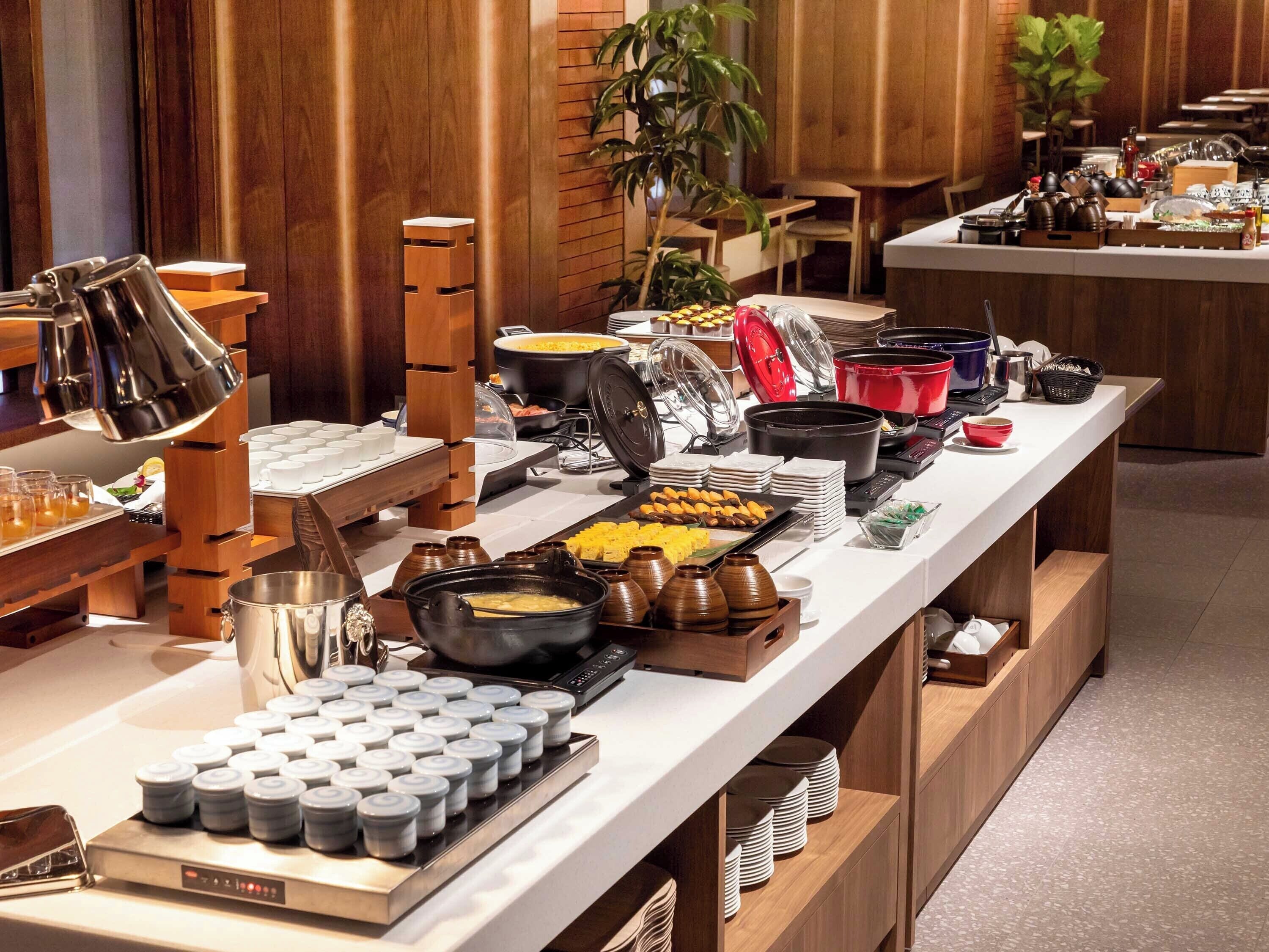 Un buffet proposant une variété de plats et d’ustensiles de service.