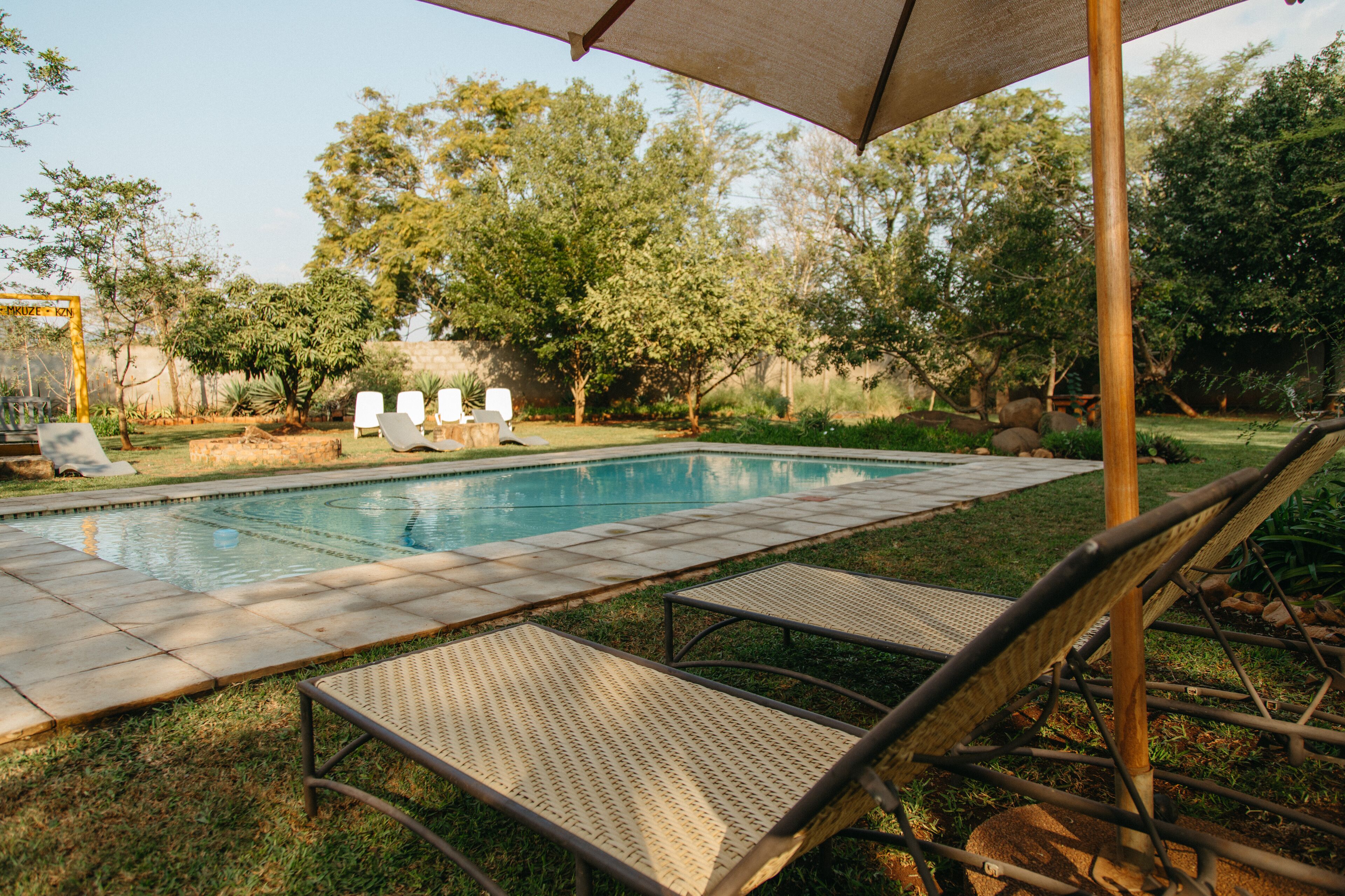 Une piscine avec des chaises longues et une pergola.