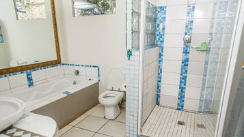 A bathroom with a bathtub, toilet, and shower.