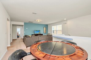 A living room with a round table, a sofa, and a TV.