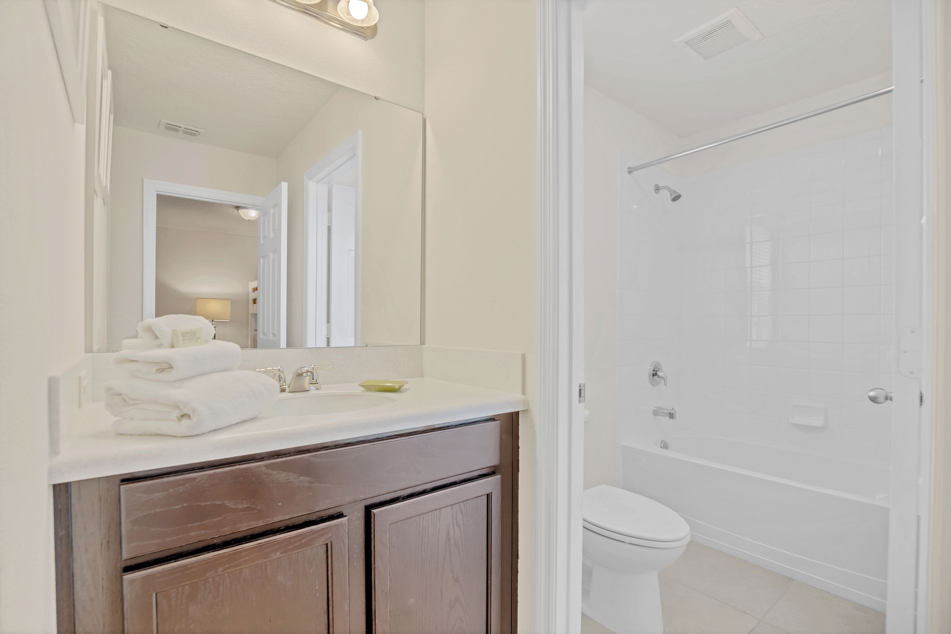 A bathroom with a white sink, mirror, and toilet.