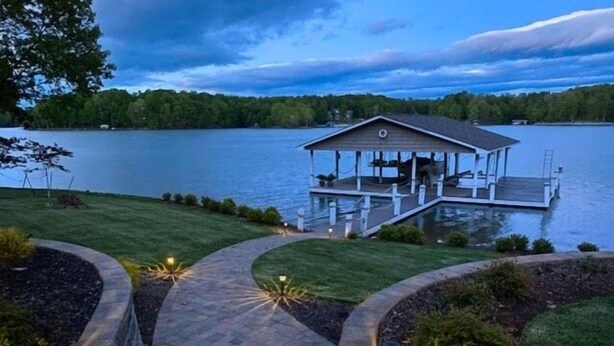 A lakeside cabin with a dock, surrounded by landscaped gardens and pathways. - Just One More Day: 2 Kayaks, Wifi, Horseshoes, Paddleboard, Panoramic View (Huddleston)