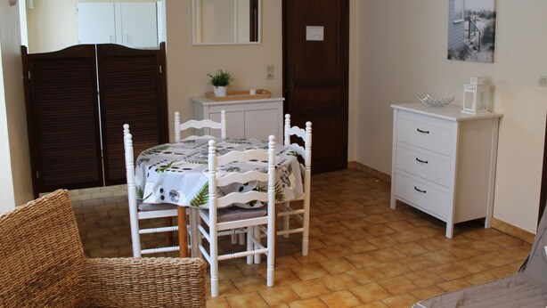 A bedroom with a bed, a dresser, a chair, a wardrobe, and a door. - Bright T2 Apartment in La Roche-Posay Center with Wi-Fi and Washer (La Roche-Posay)